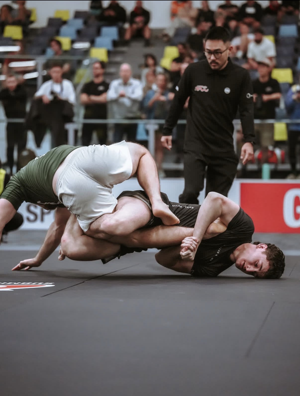 A Mat Shark athlete finishing a takedown at a no-gi competition