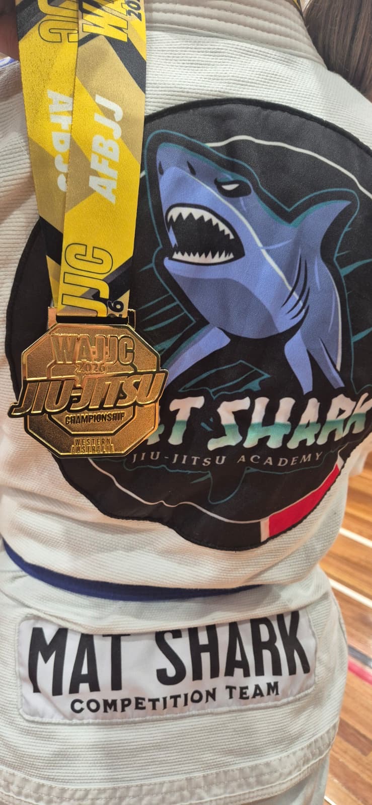 WAJJC gold medal hanging on a Mat Shark competition team gi