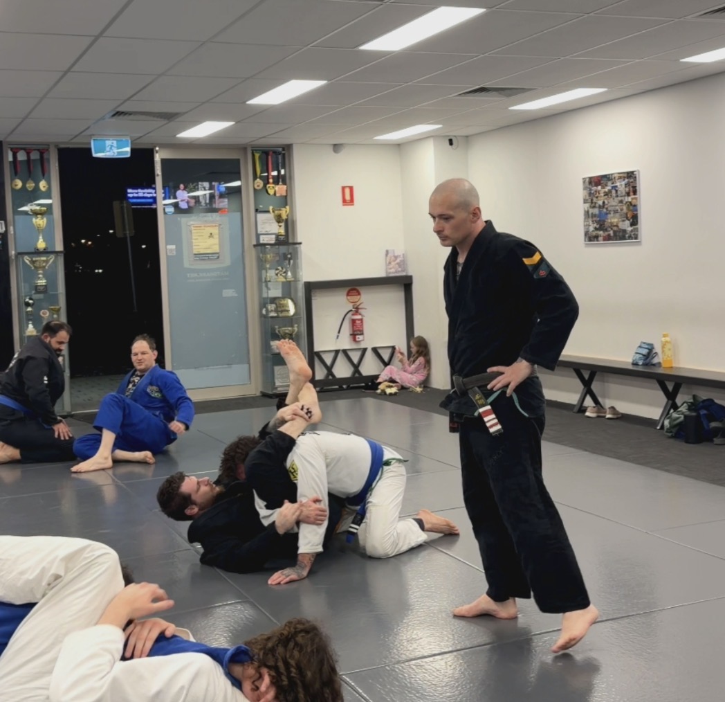 A Mat Shark coach watching a live round in the gi