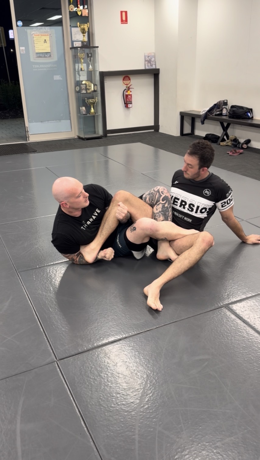 A coach showing a technique on the mats at Mat Shark