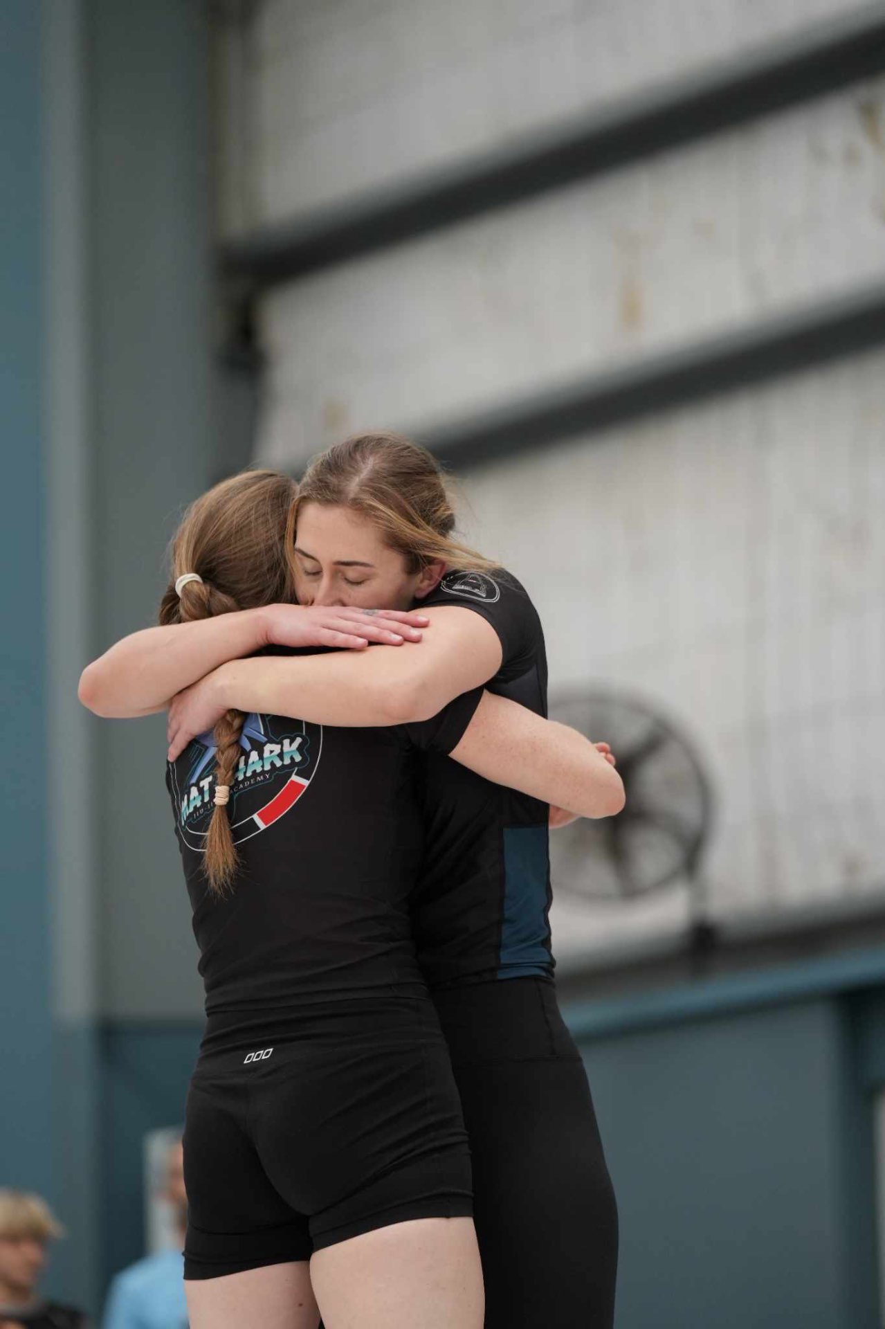 Two Mat Shark teammates hugging after a match