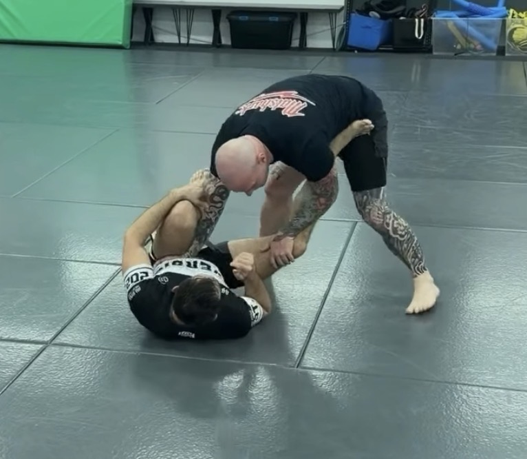 A coach working standing guard passing with a student at Mat Shark