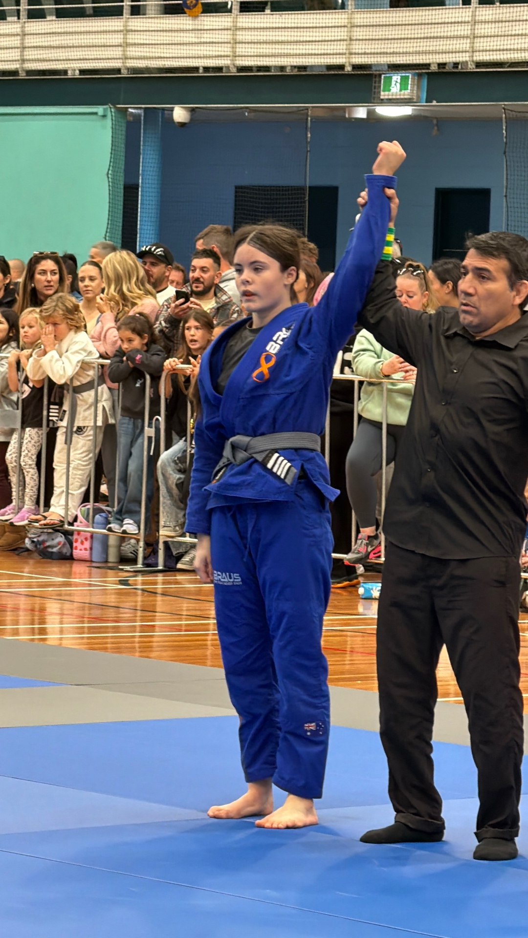 A Mat Shark girl having her hand raised after winning her gi match