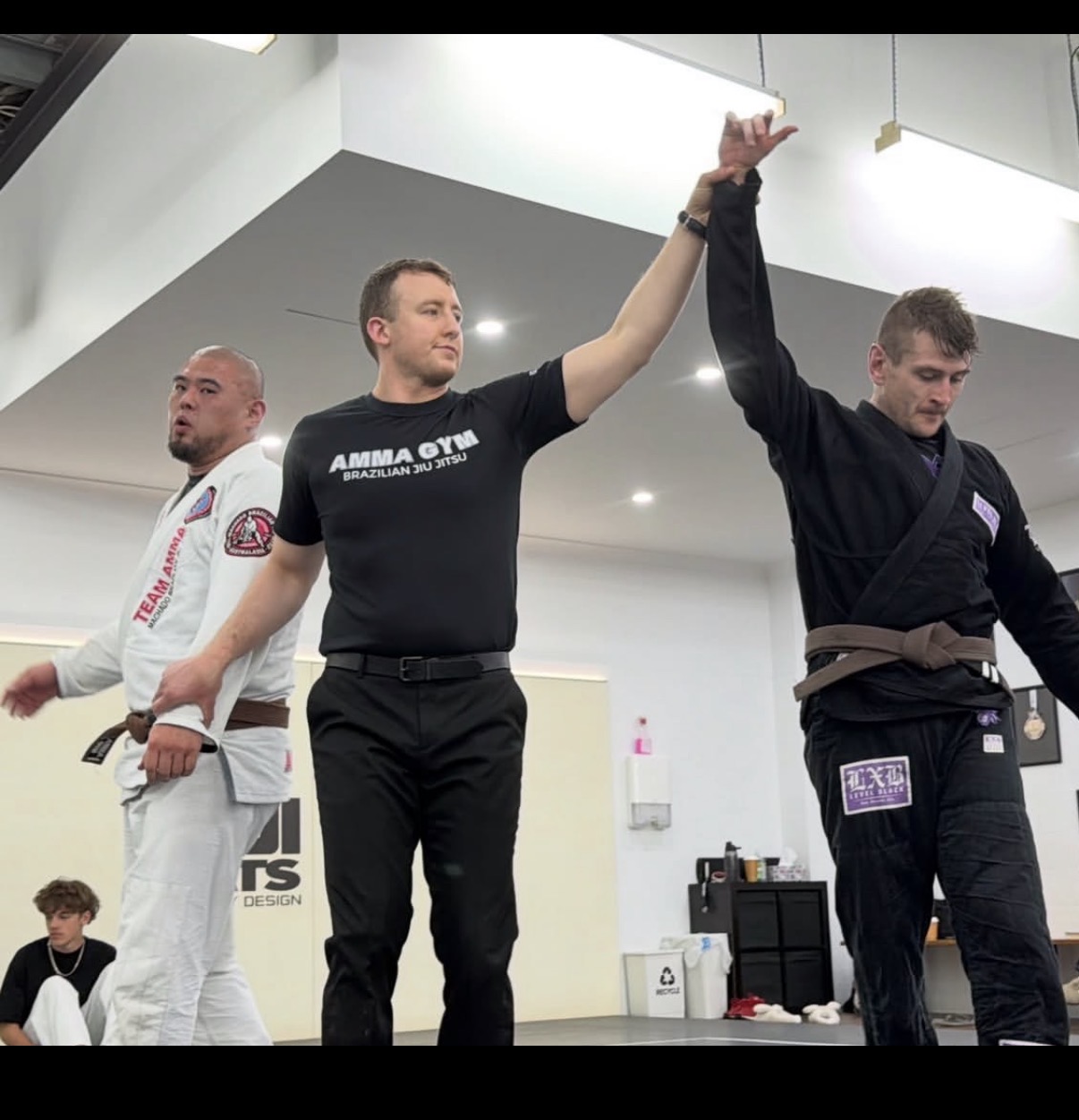 A Mat Shark brown belt having his hand raised after a gi match