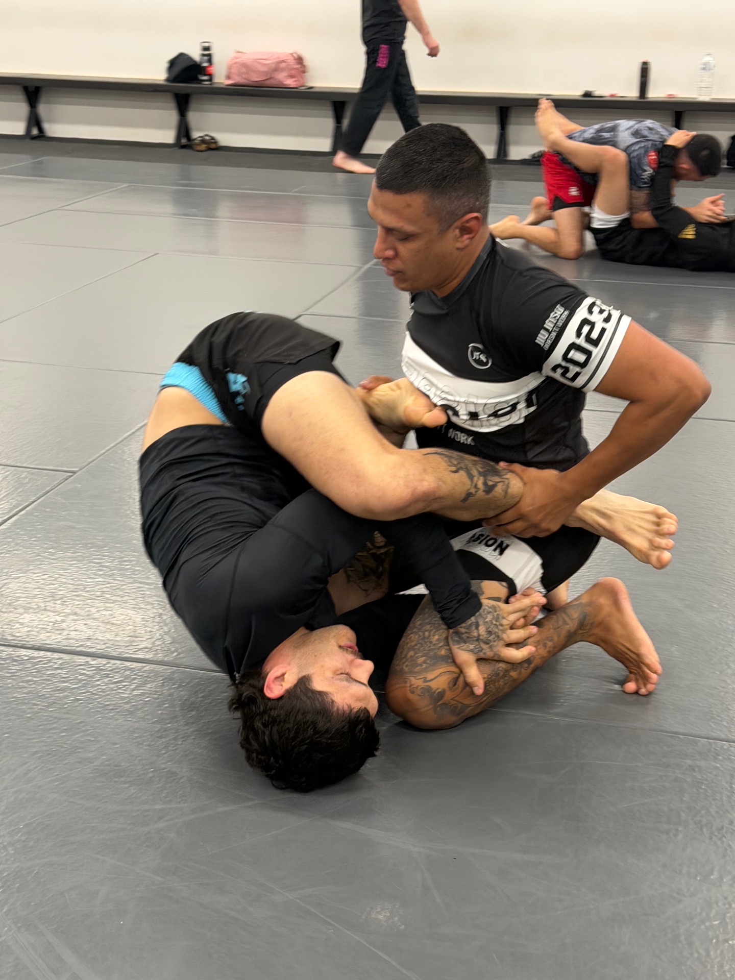 Two students in a no-gi round on the mats at Mat Shark