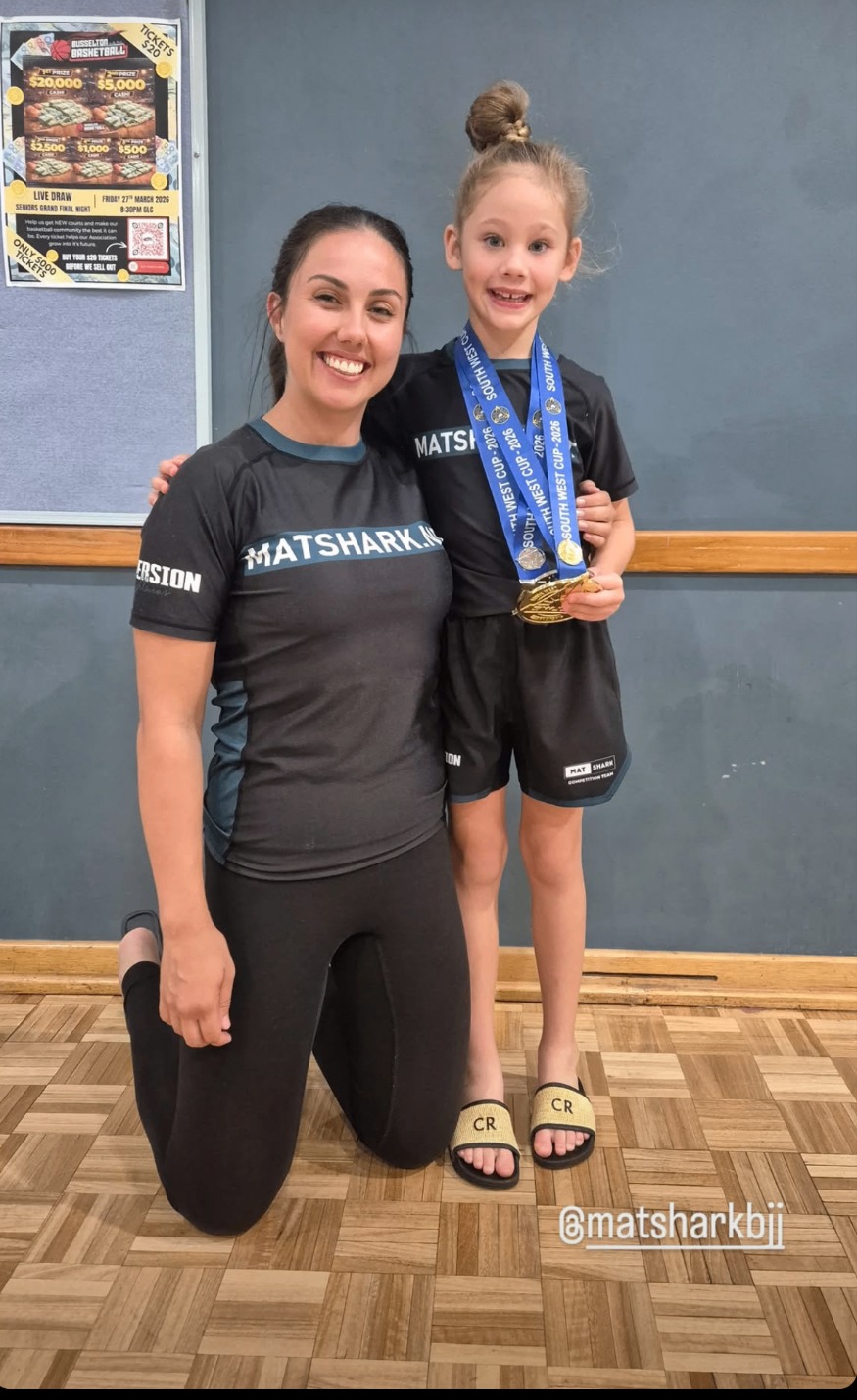 A young Mat Shark competitor with her medals and her mum
