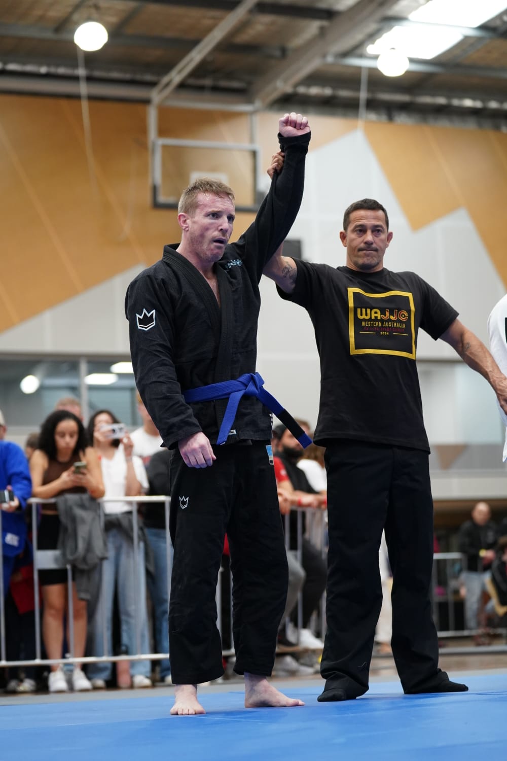 A Mat Shark blue belt having his hand raised after a win