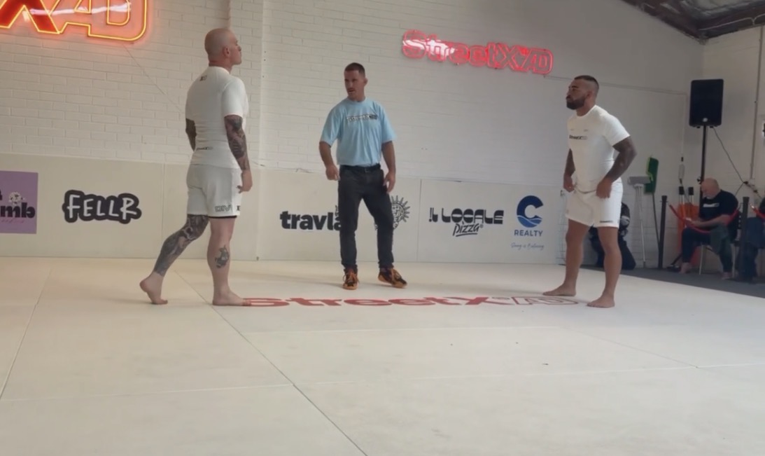 Two grapplers facing off with the referee before a superfight